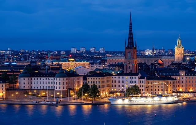 Stockholm waterfront at twilight with city lights reflected in the water, Swedish TV for expats