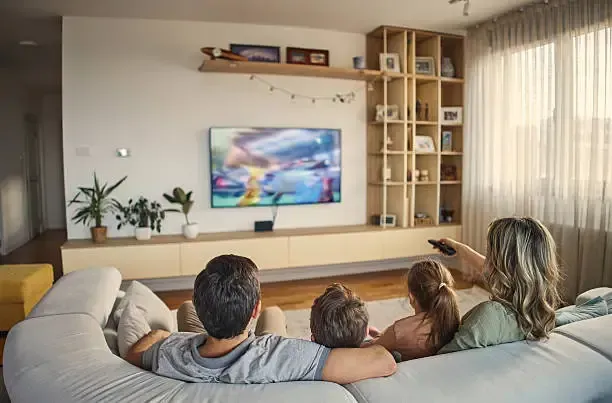 Family relaxing together watching IPTV streaming service on television