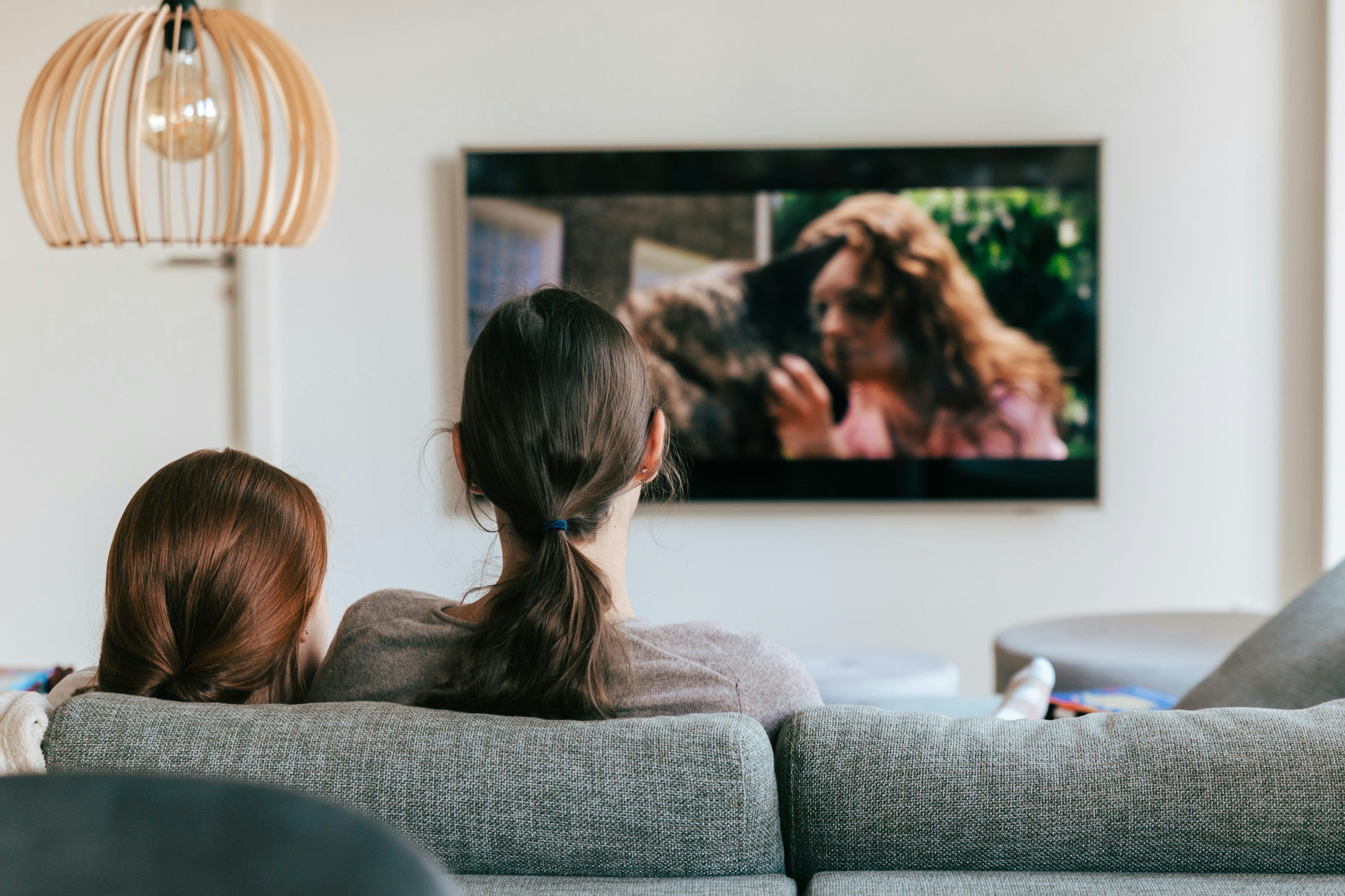 Family enjoying IPTV on demand content on a large smart TV in a living room